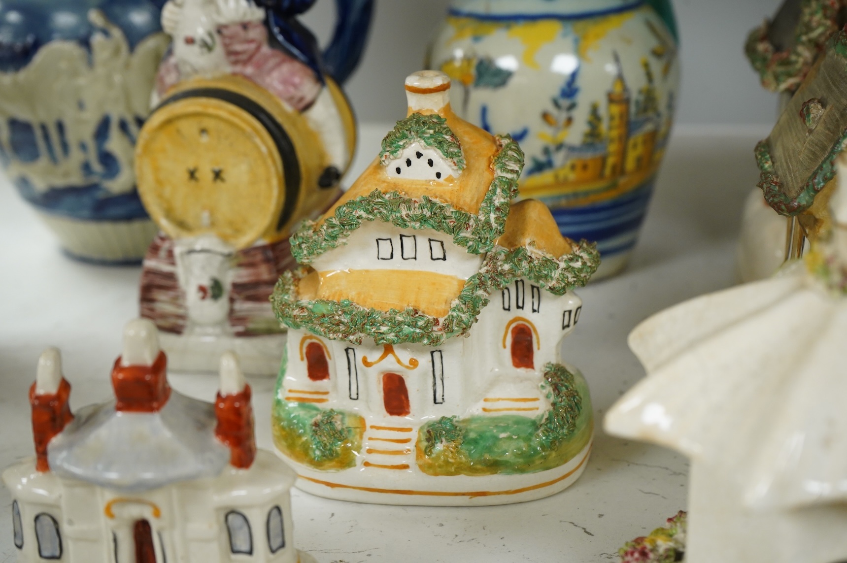 A group of various Victorian Staffordshire pottery models of cottages and various figure moulded vessels together with an Italian maiolica ewer, tallest 25cm